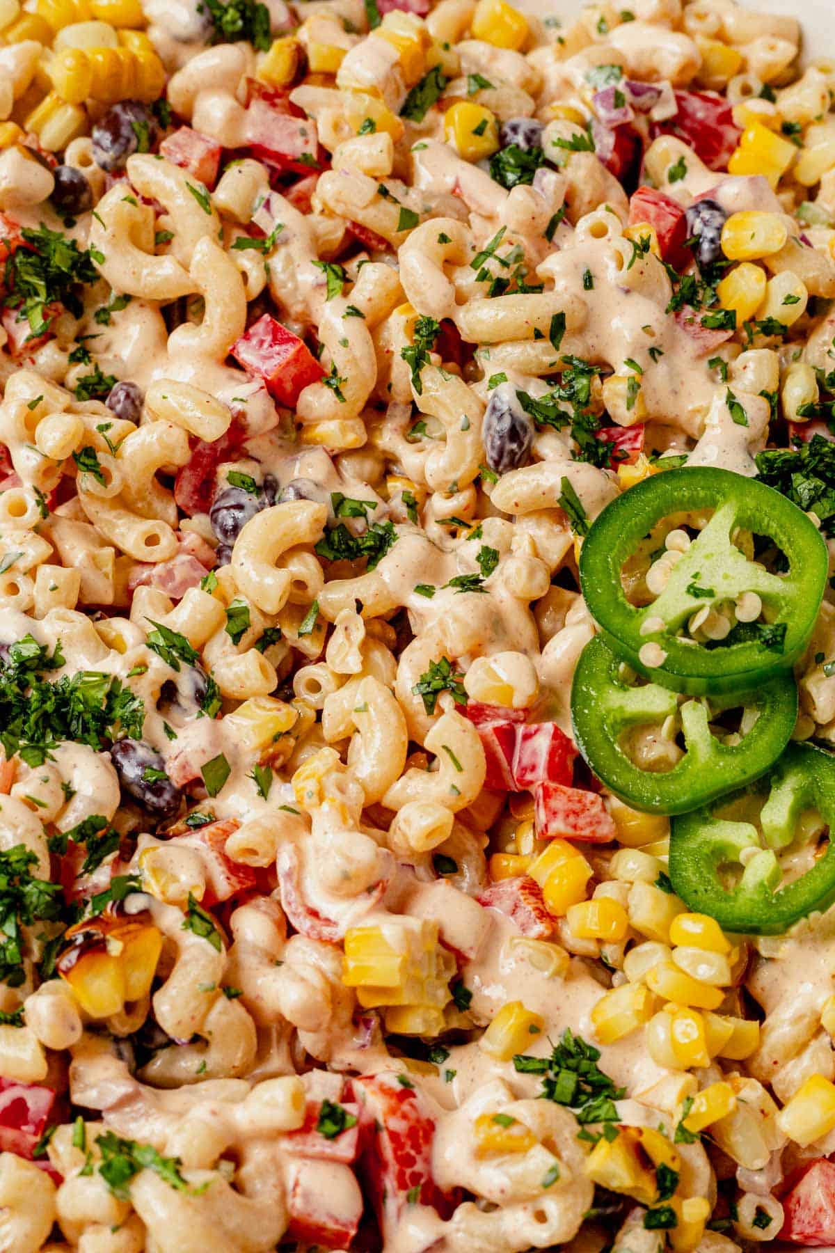 mexican macaroni salad with dressing and cilantro on top