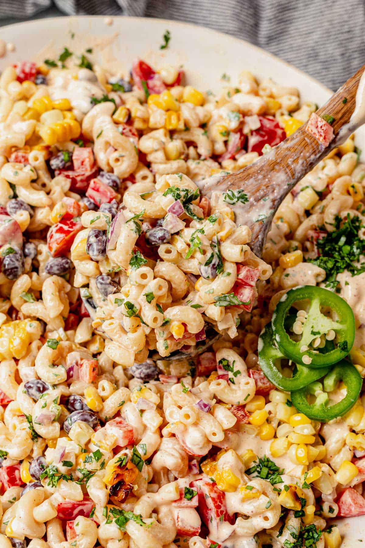 scooping mexican macaroni salad from a serving bowl