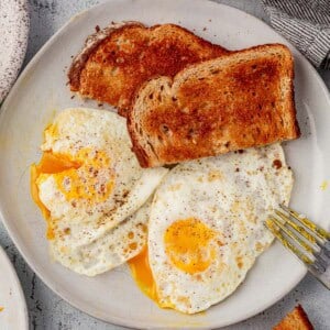 two over medium eggs on a plate with toast