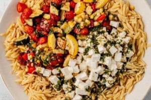 roasted vegetables, orzo, and dressing in a serving bowl