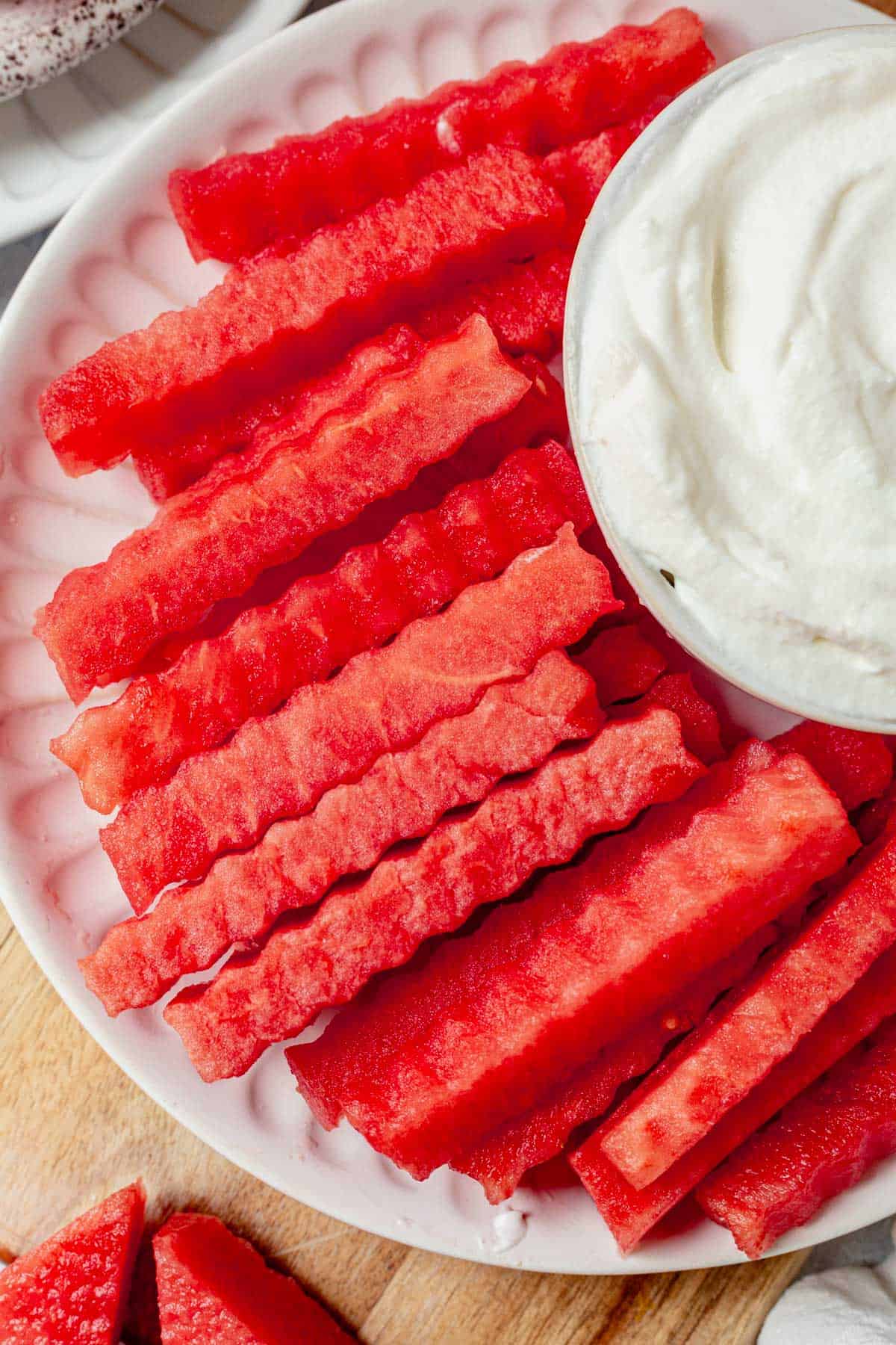 watermelon fries on a plate with whipped cream yogurt dip