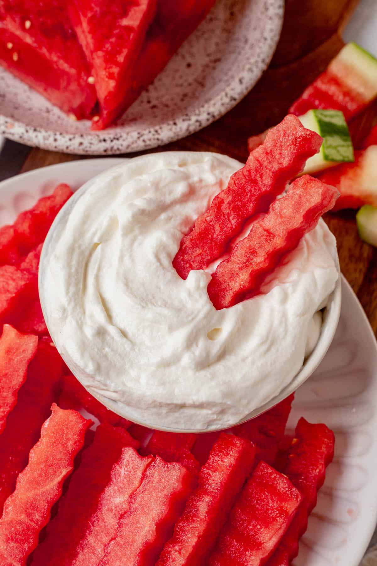 two watermelon fries in a bowl of yogurt dip