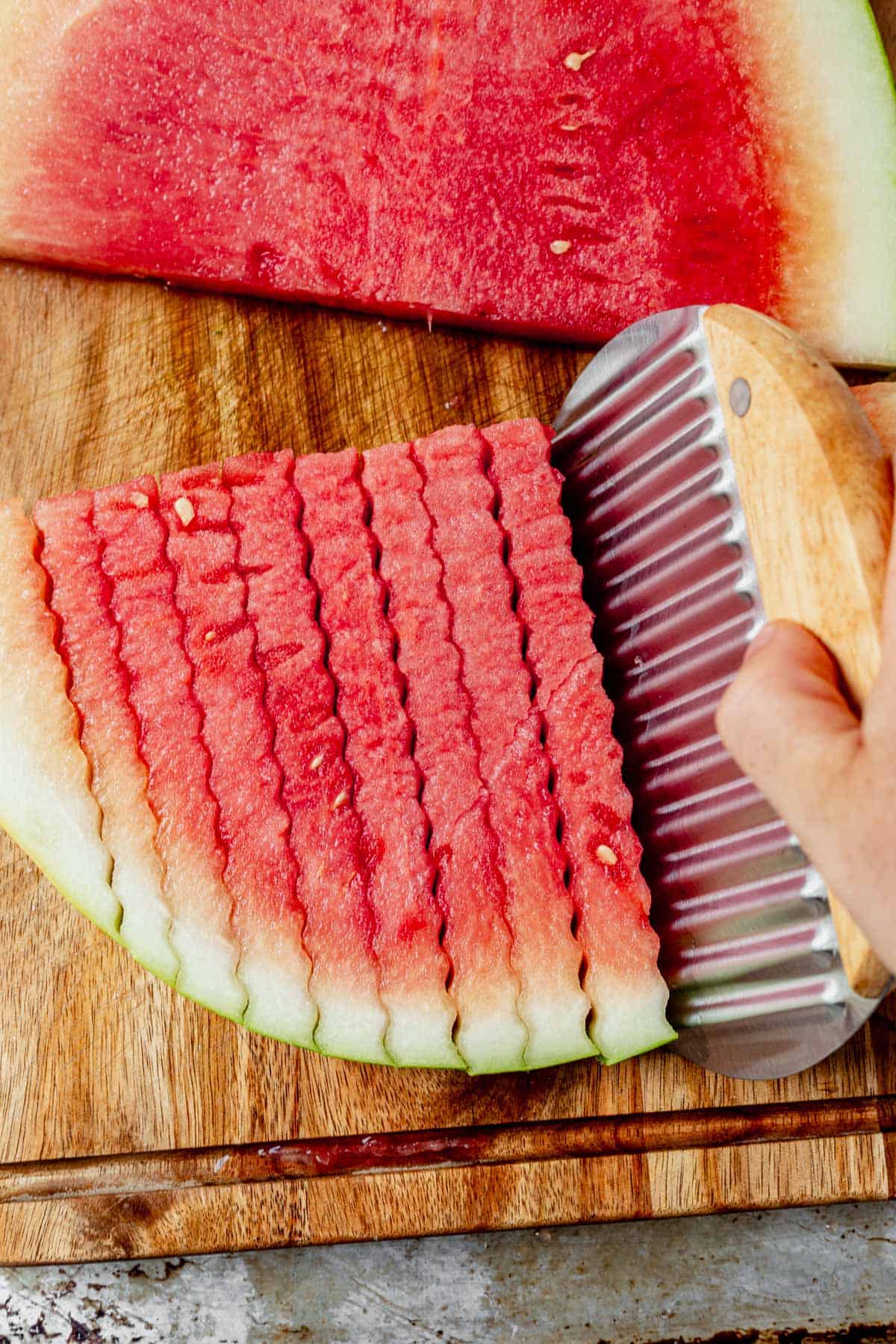 cutting a slice of watermelon with a crinkle cutter knife