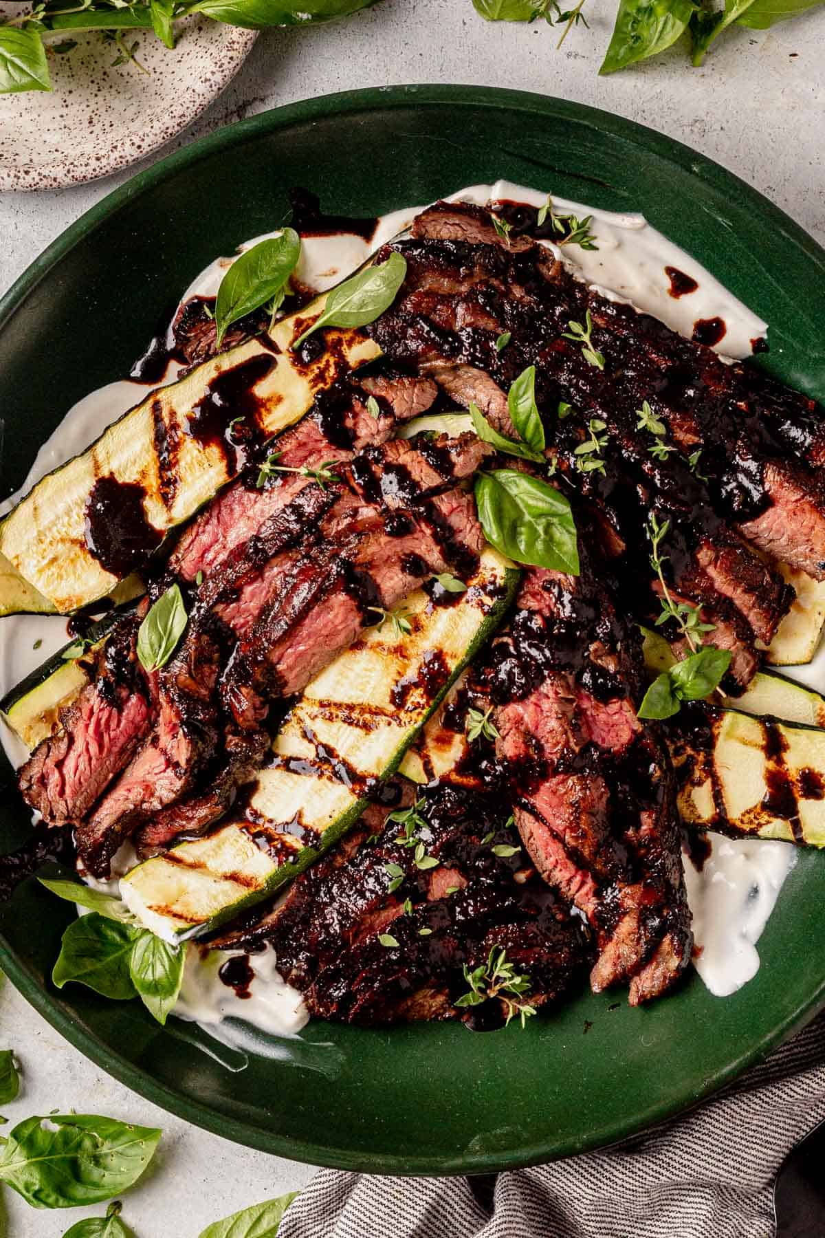 balsamic flank steak thinly sliced in a serving bowl with zucchini