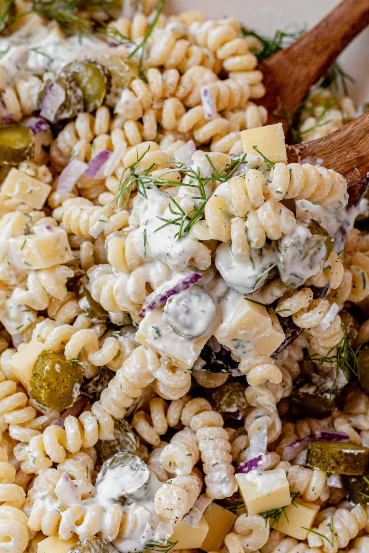 serving spoon in a bowl of dill pickle pasta salad