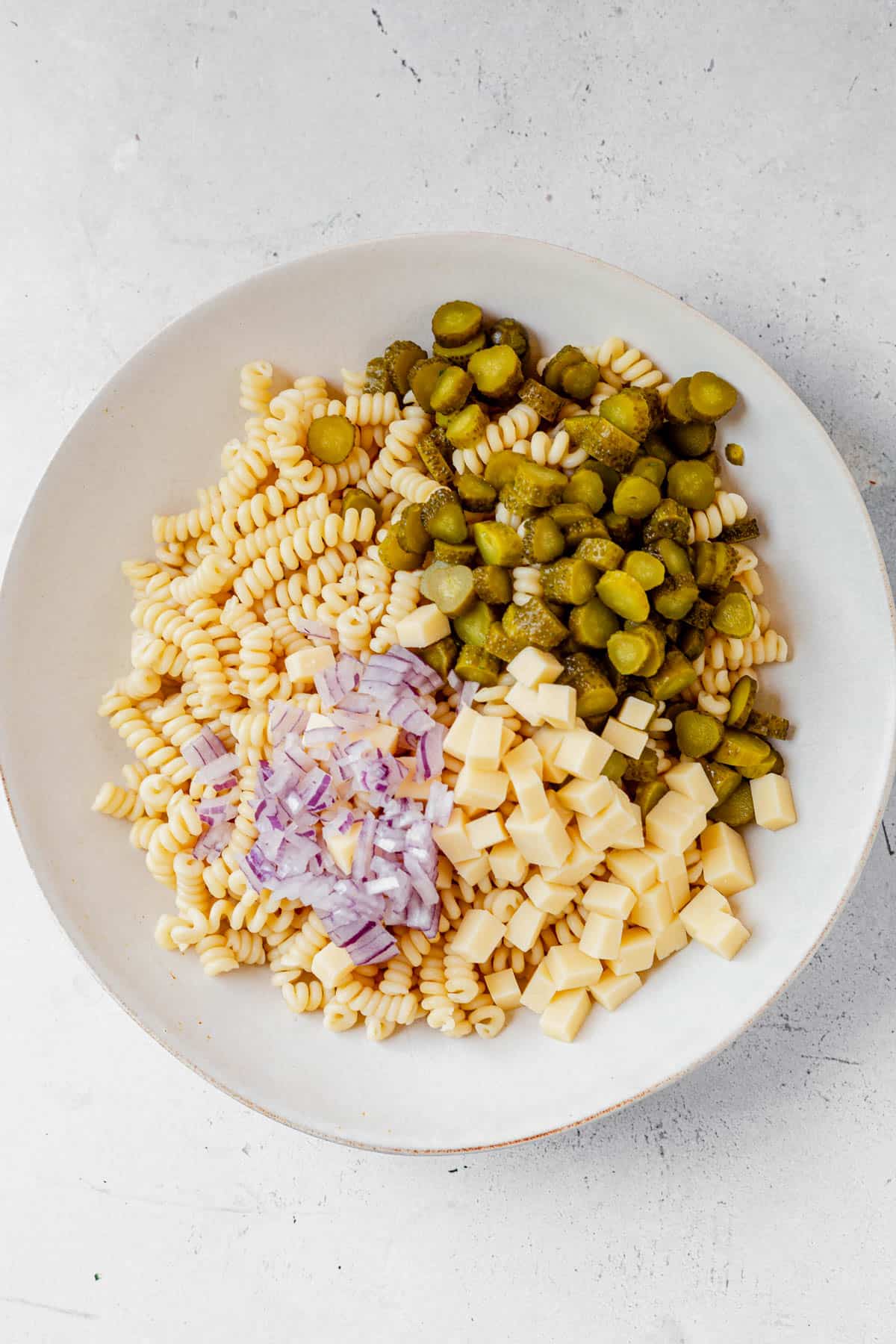 dill pickle pasta salad ingredients in a serving bowl