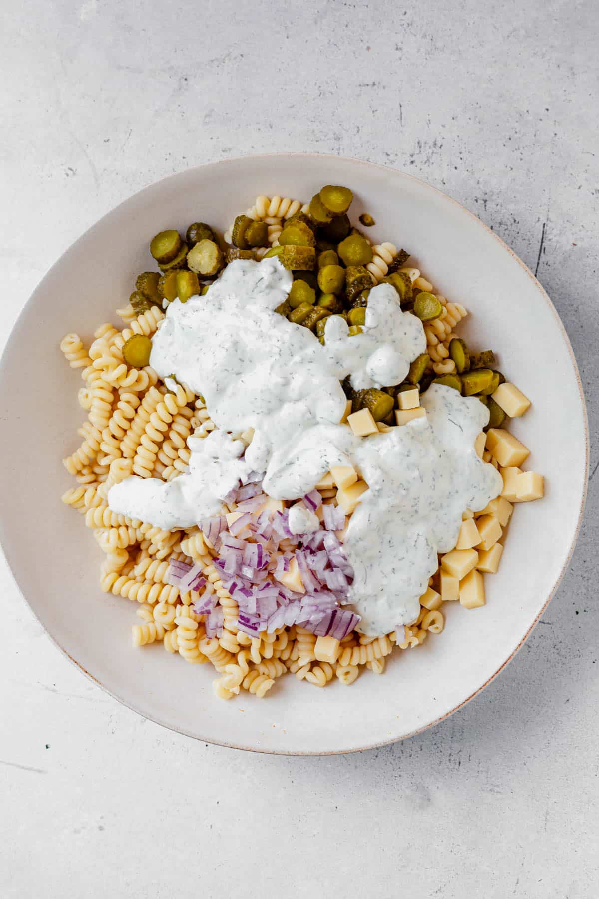 ranch dressing covering dill pickle pasta salad