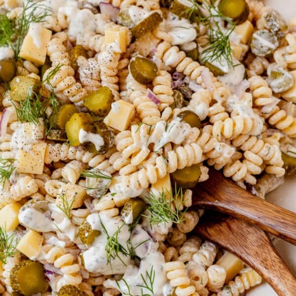 dill pickle pasta salad in a bowl with serving spoons