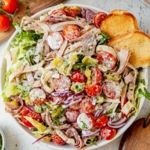 grinder salad in a bowl with a toasted hoagie