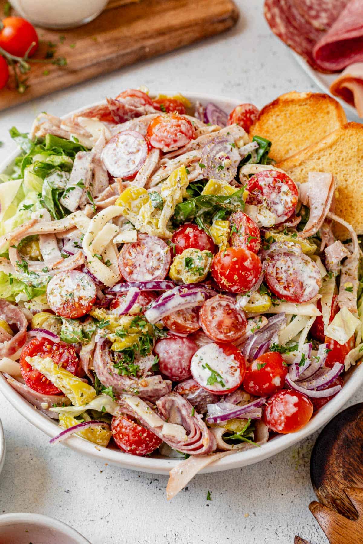 grinder salad in a bowl with a toasted hoagie