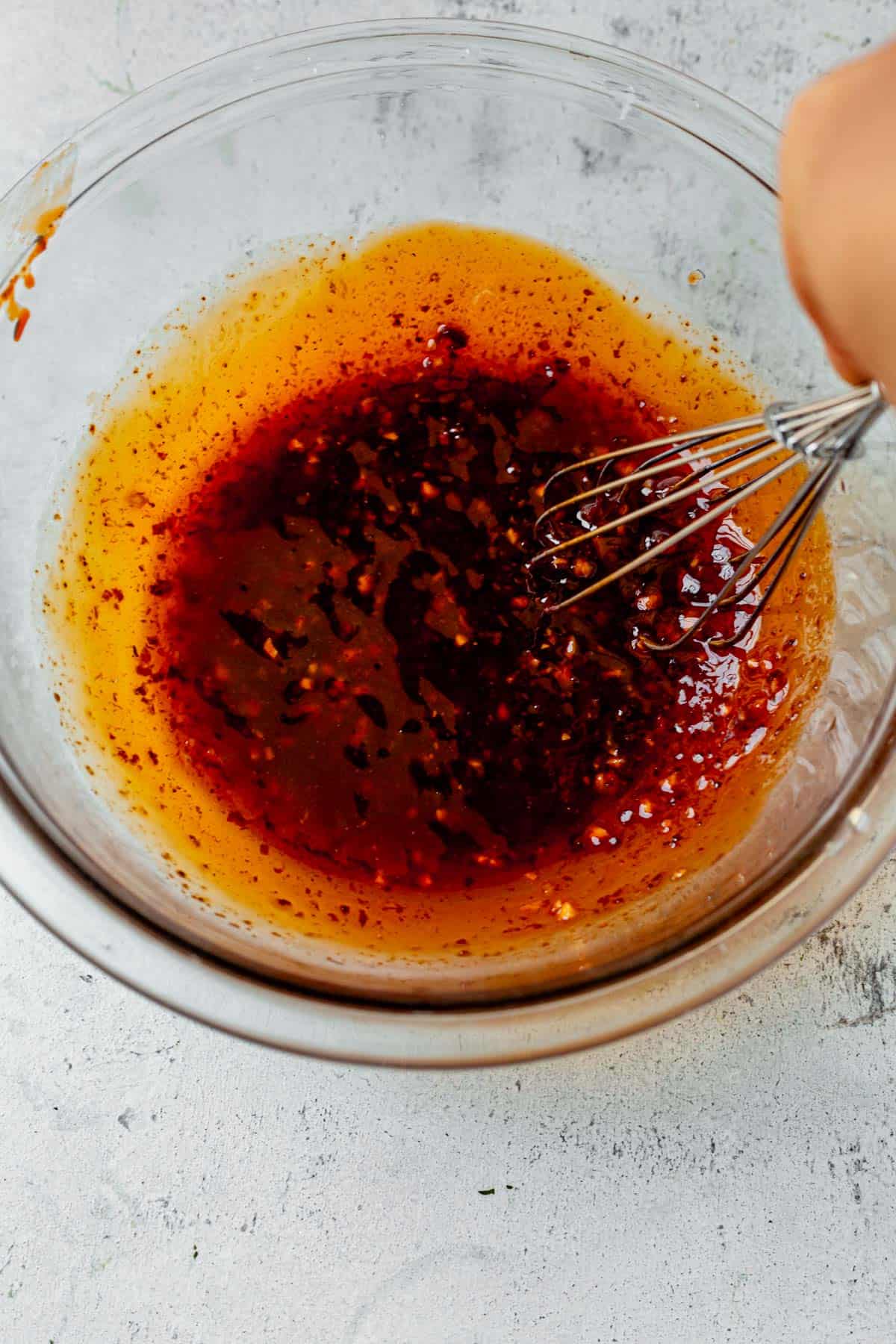 whisking harissa marinade in a bowl