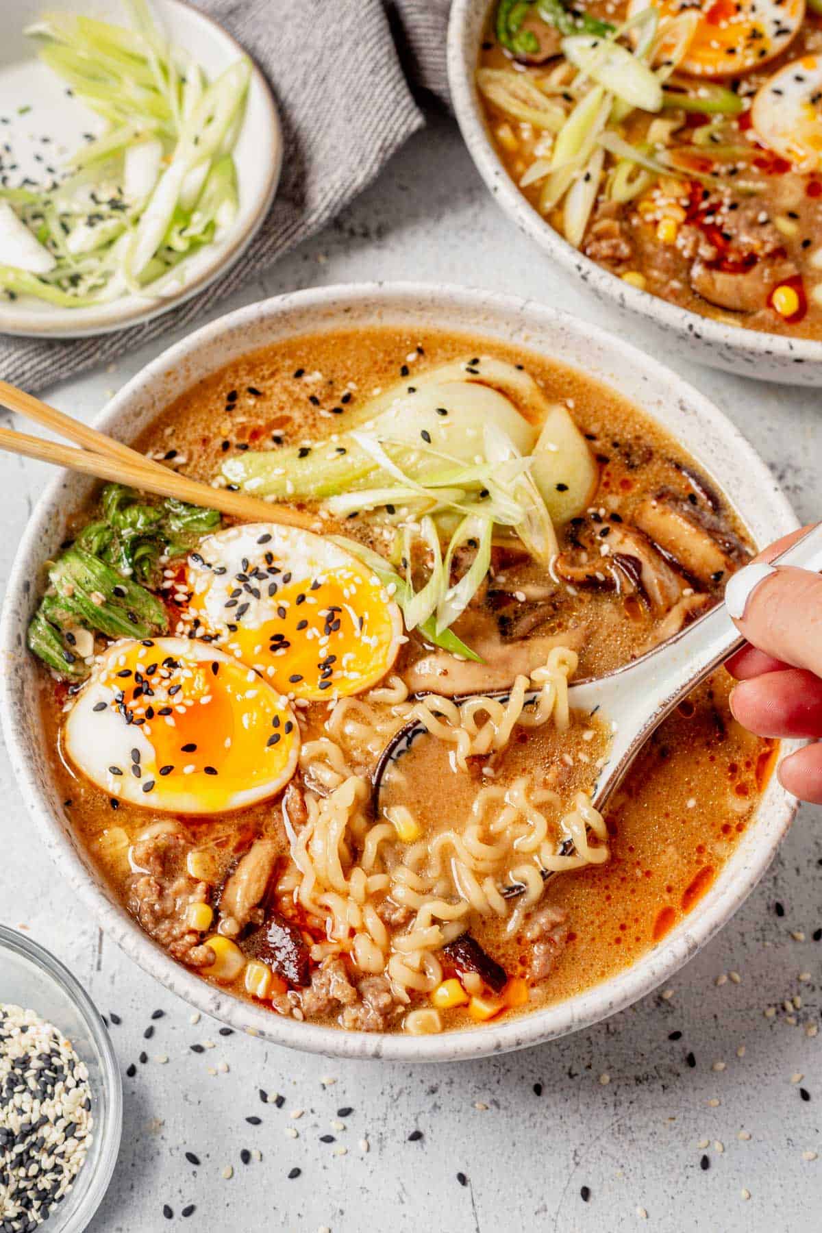 a bowl of miso pork ramen with chop sticks and thai soup spoon