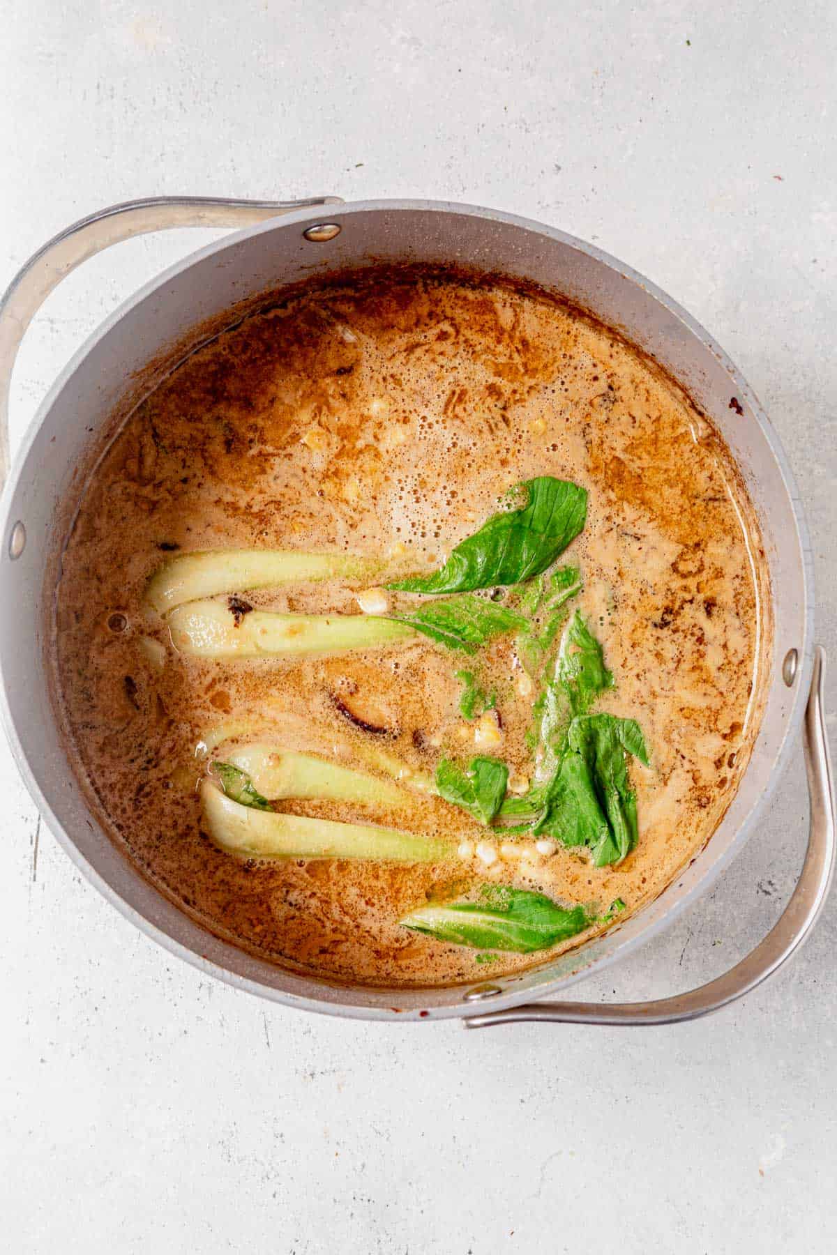 corn and bok choy cooking in miso ramen broth