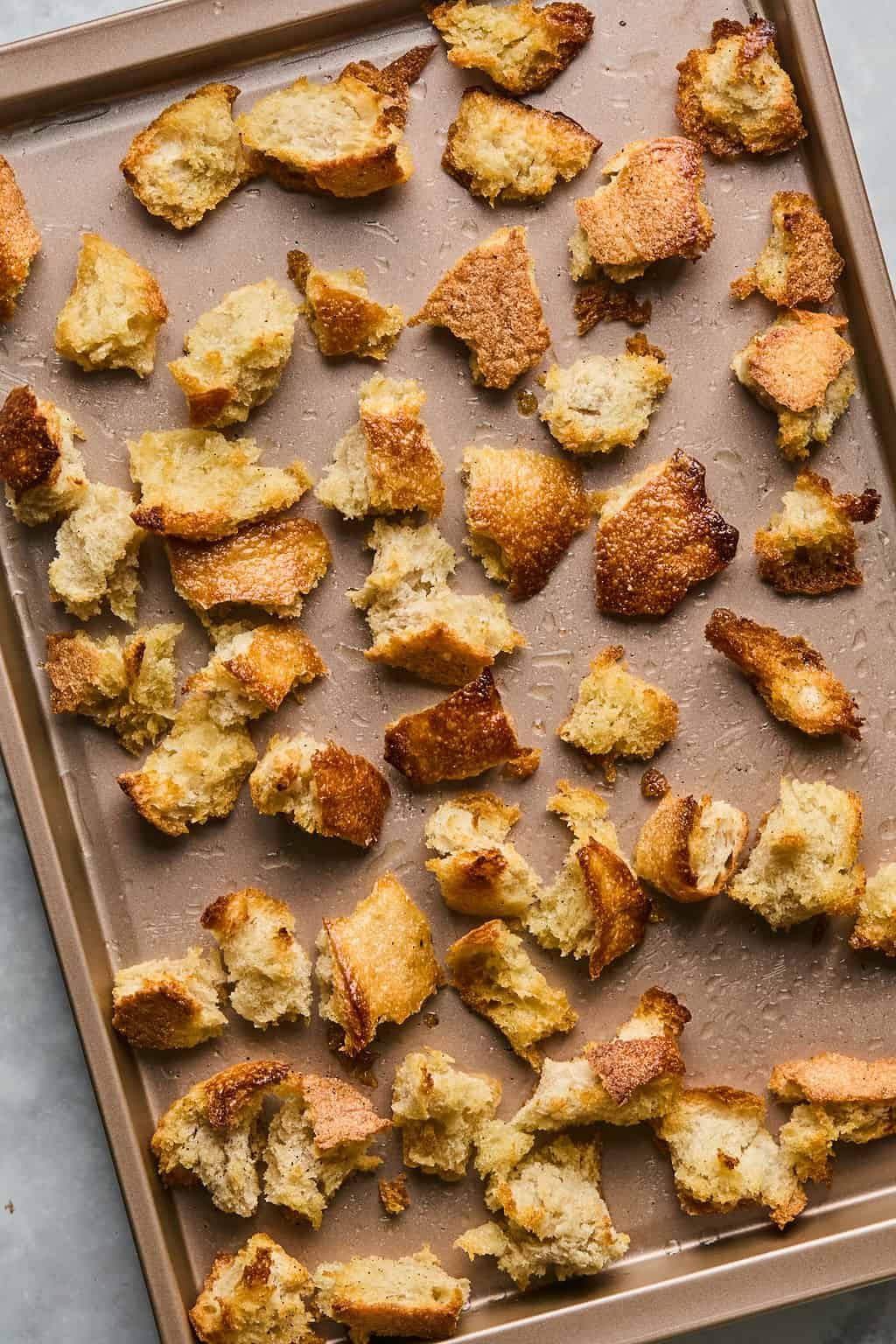 toasted sourdough croutons spread on a baking sheet.