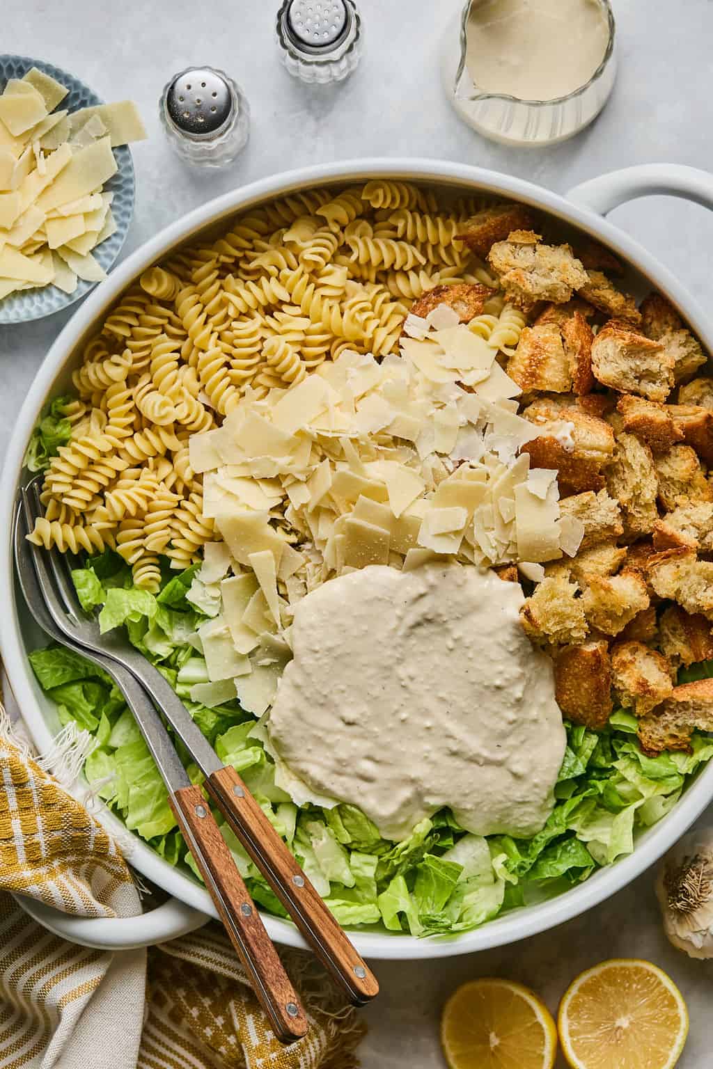 caesar dressing on top of pasta salad in a bowl.