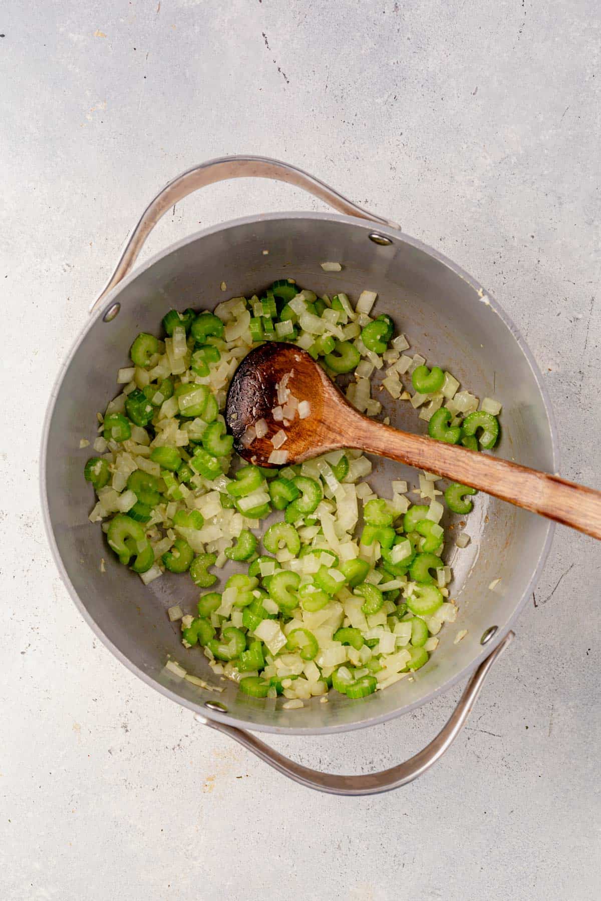 onion and celery satueed in a stock pot.