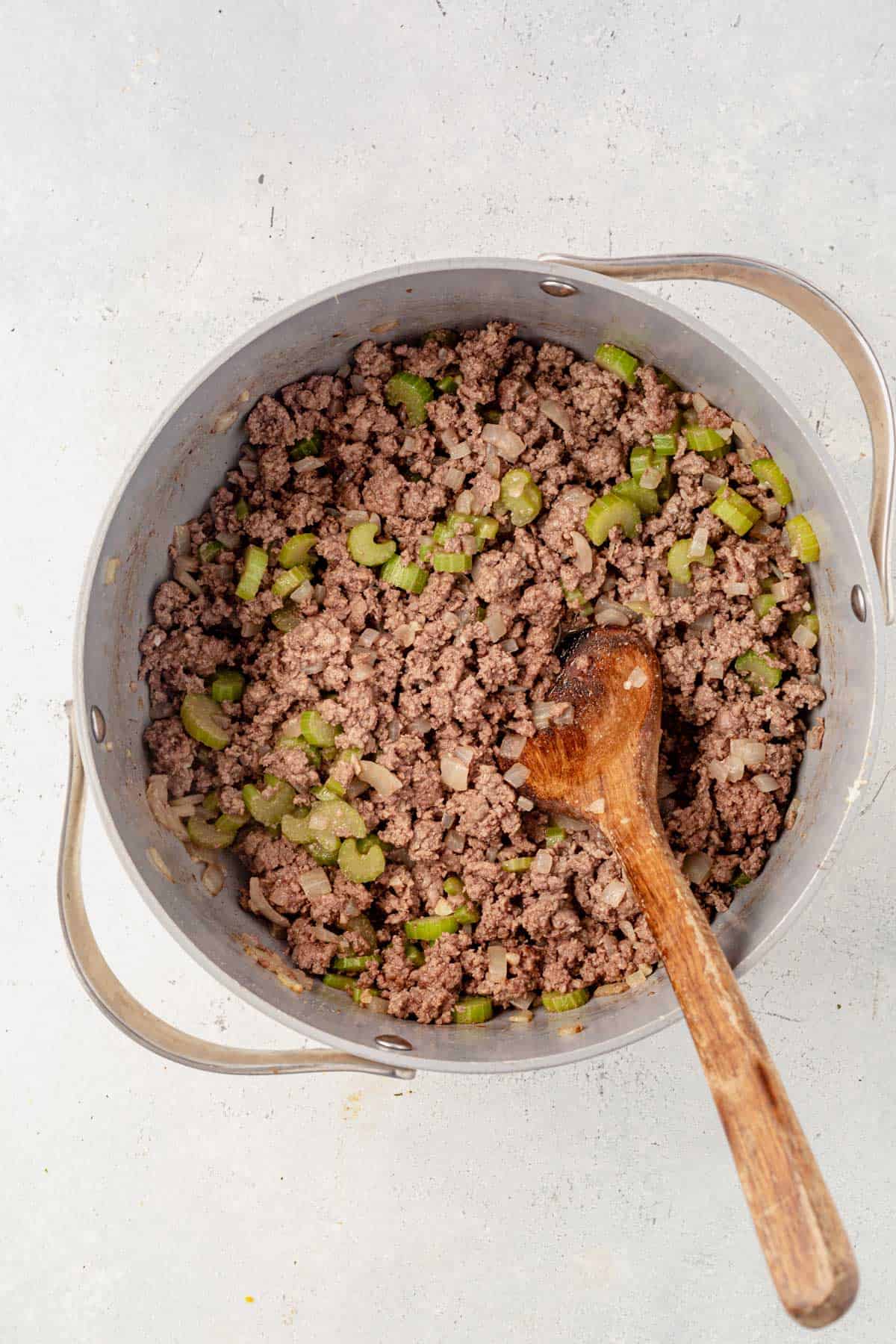 ground beef in a soup pot with onion and celery.