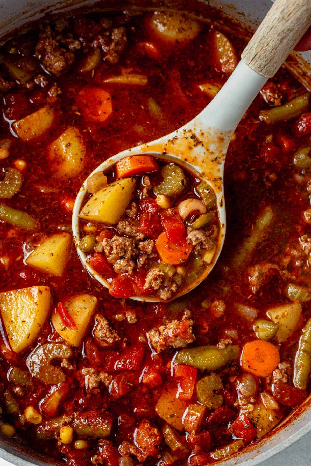 ladling cowboy hamburger soup out of a stock pot.