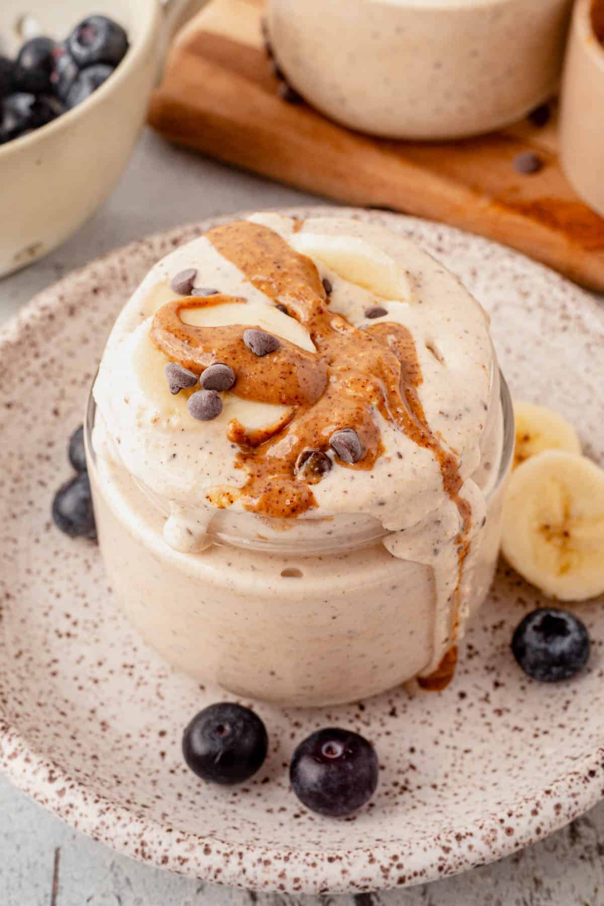 blended protein overnight oats in a glass jar with almond butter on top.