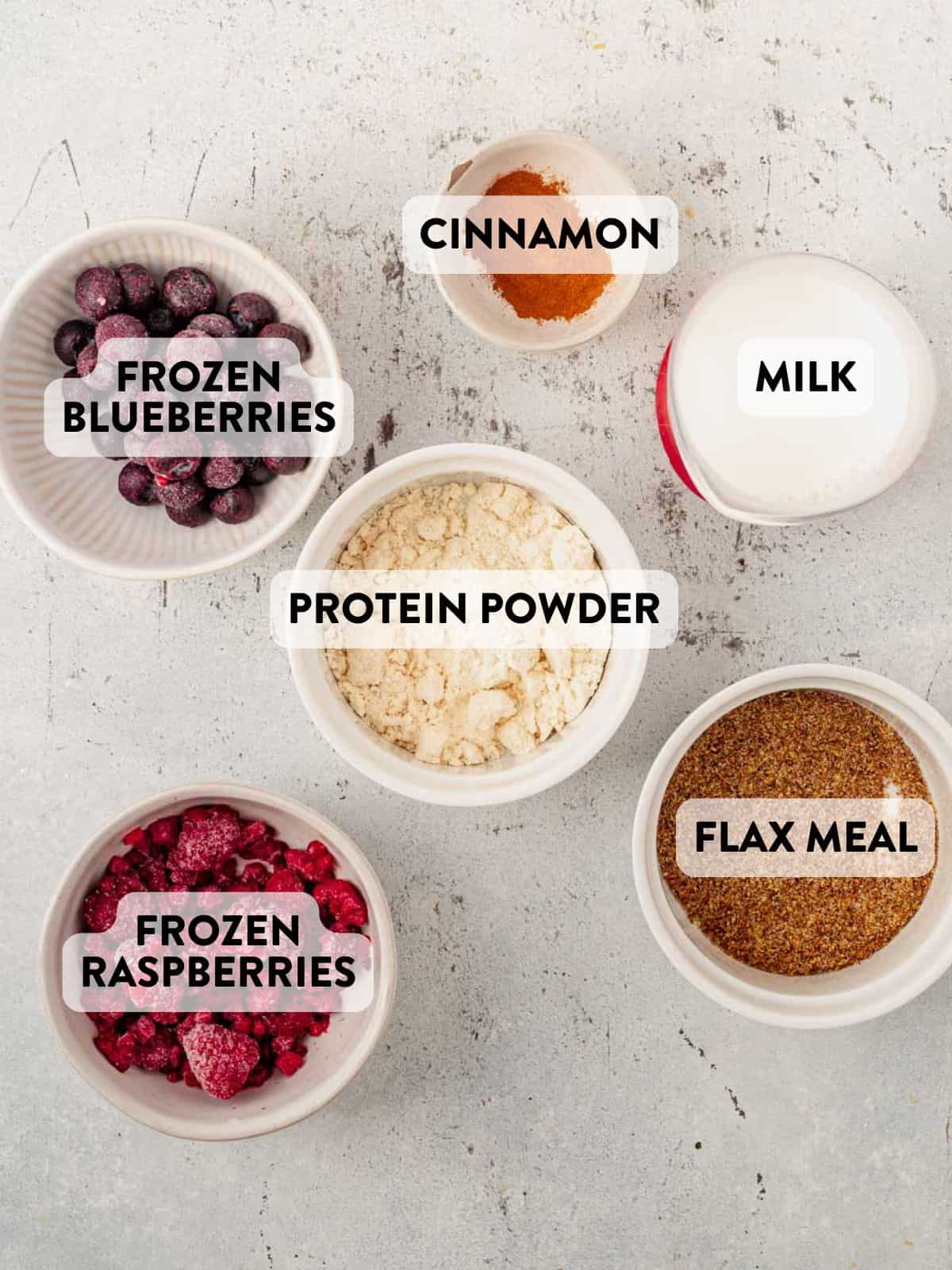 ingredients for a blueberry raspberry smoothie on a countertop.