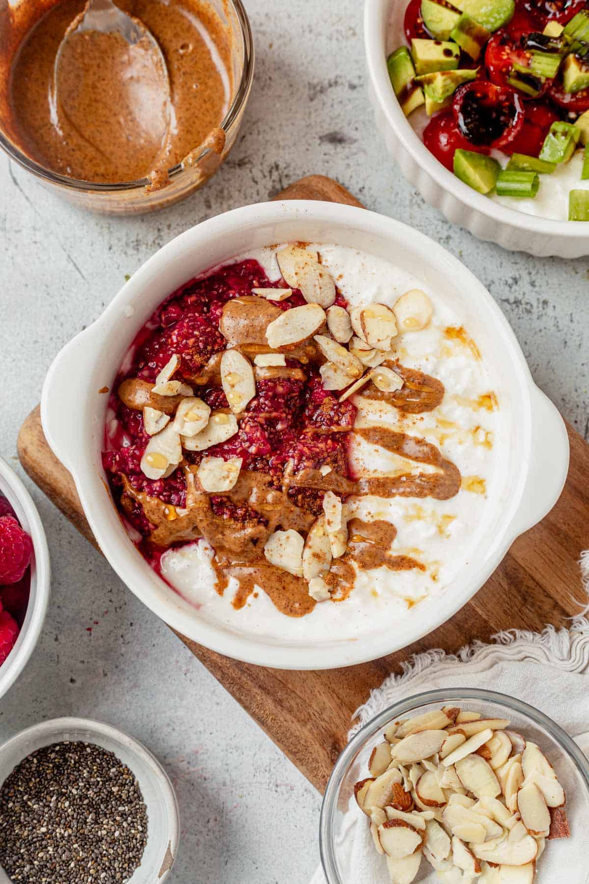 cottage cheese breakfast bowl with chia jam, nut butter, and almonds on a tray.