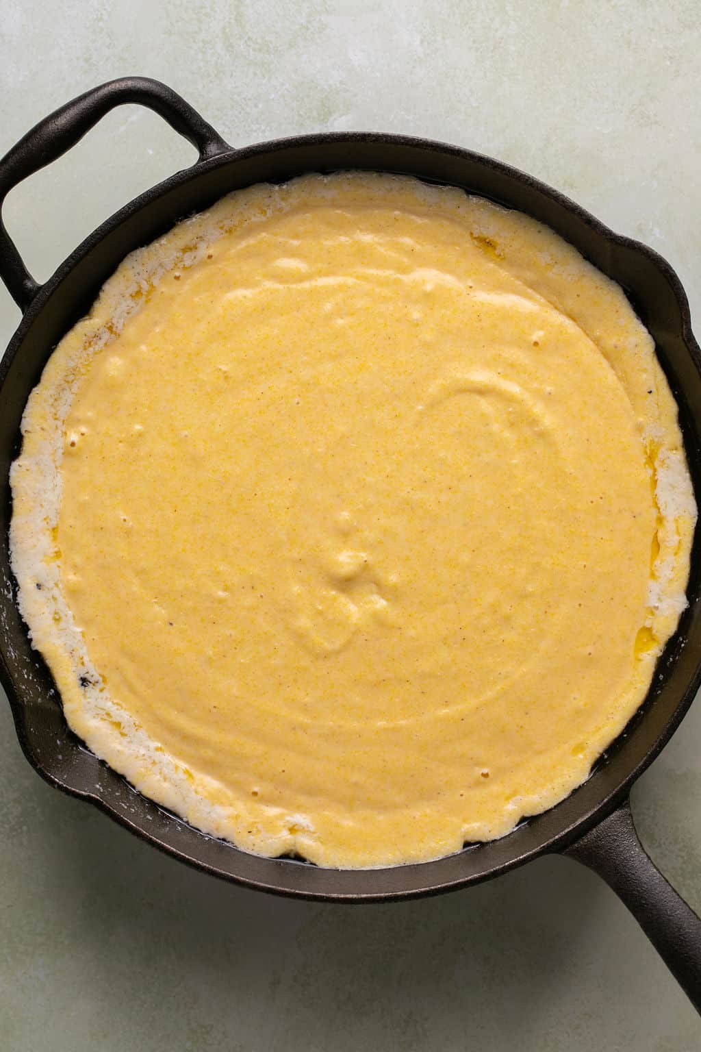 gluten free cornbread batter in a cast iron skillet.