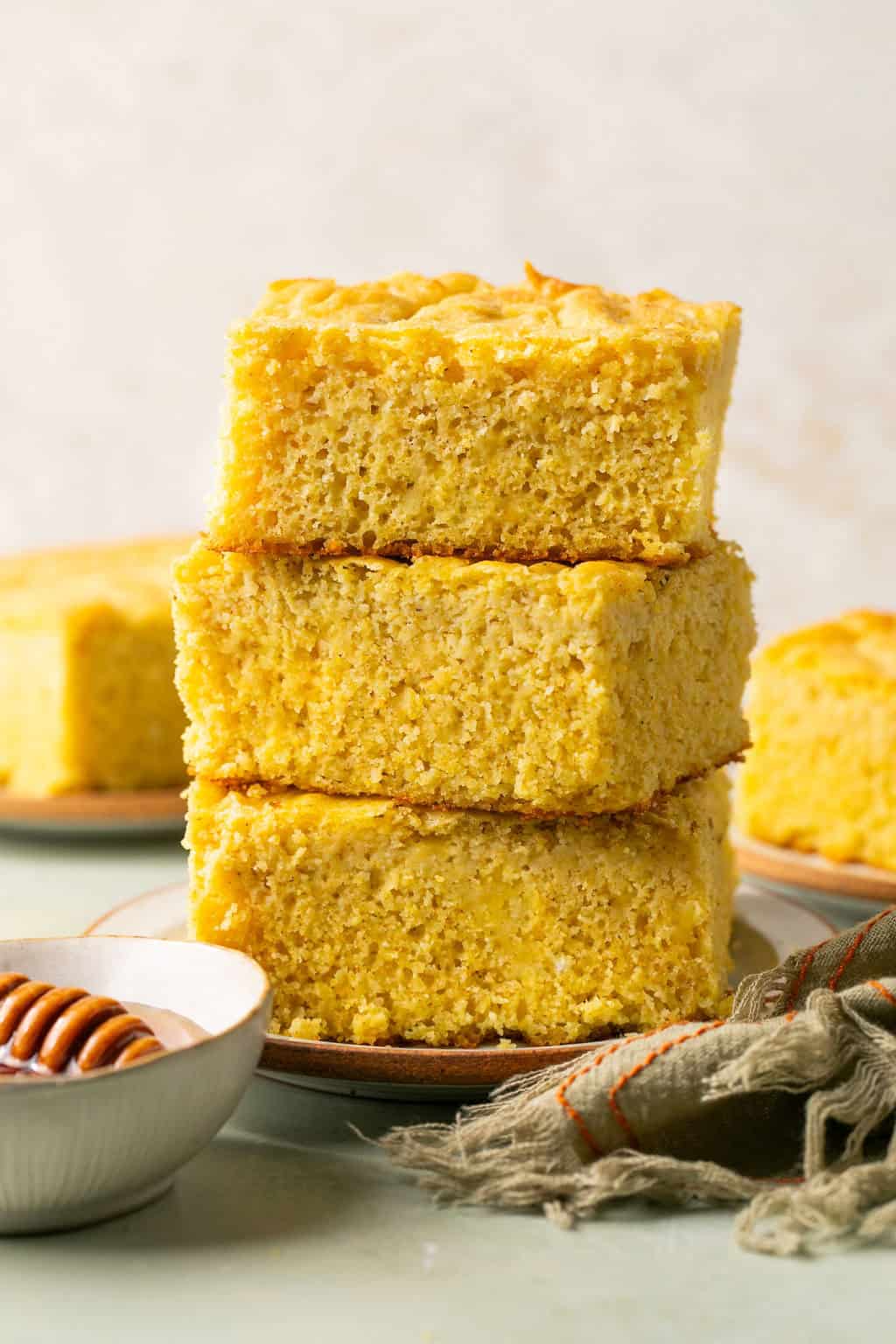 three pieces of gluten free cornbread stacked on a plate.