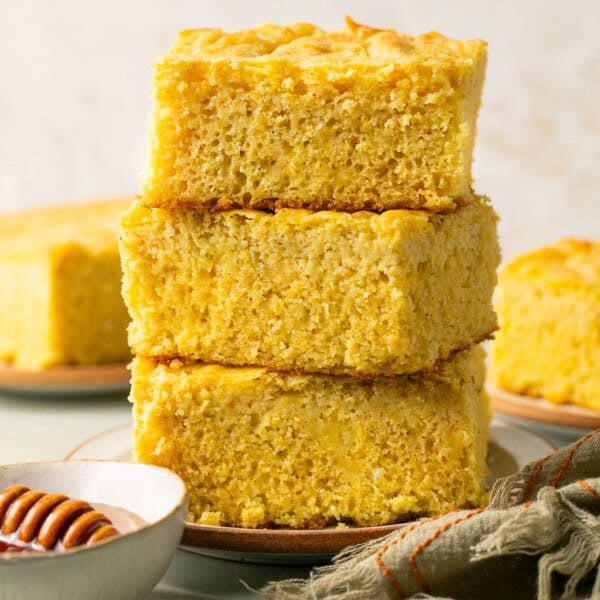 three pieces of gluten free cornbread stacked on a plate.