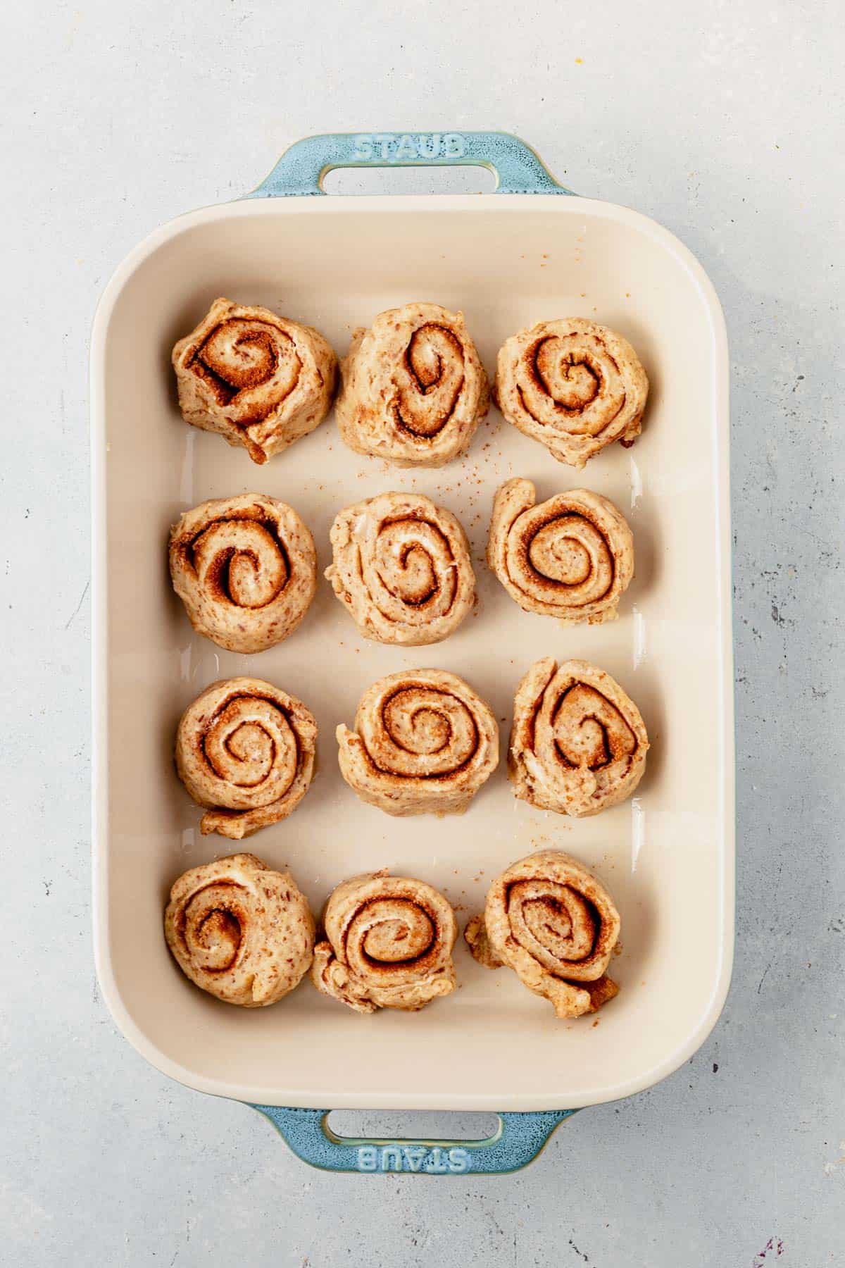 unbaked cinnamon rolls in a baking dish before rising.