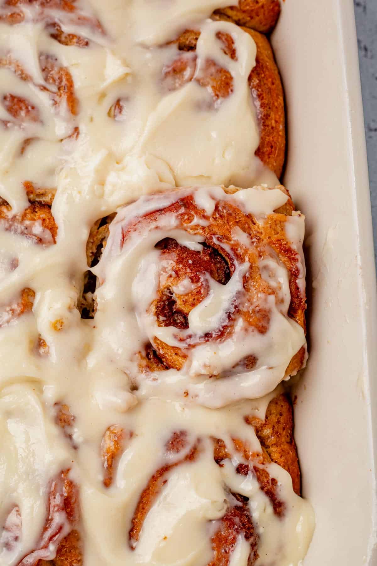 frosted protein cinnamon rolls in a baking dish.