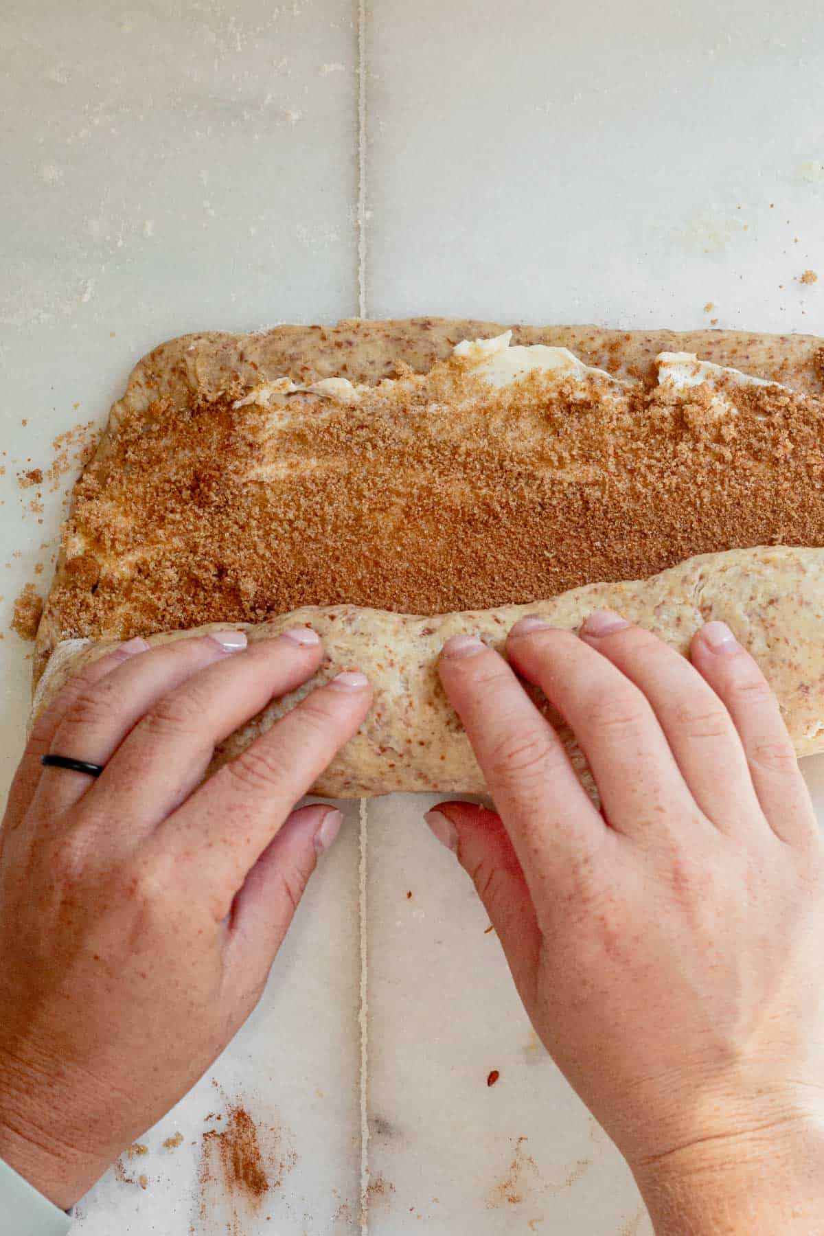 rolling cinnamon roll dough into a log.