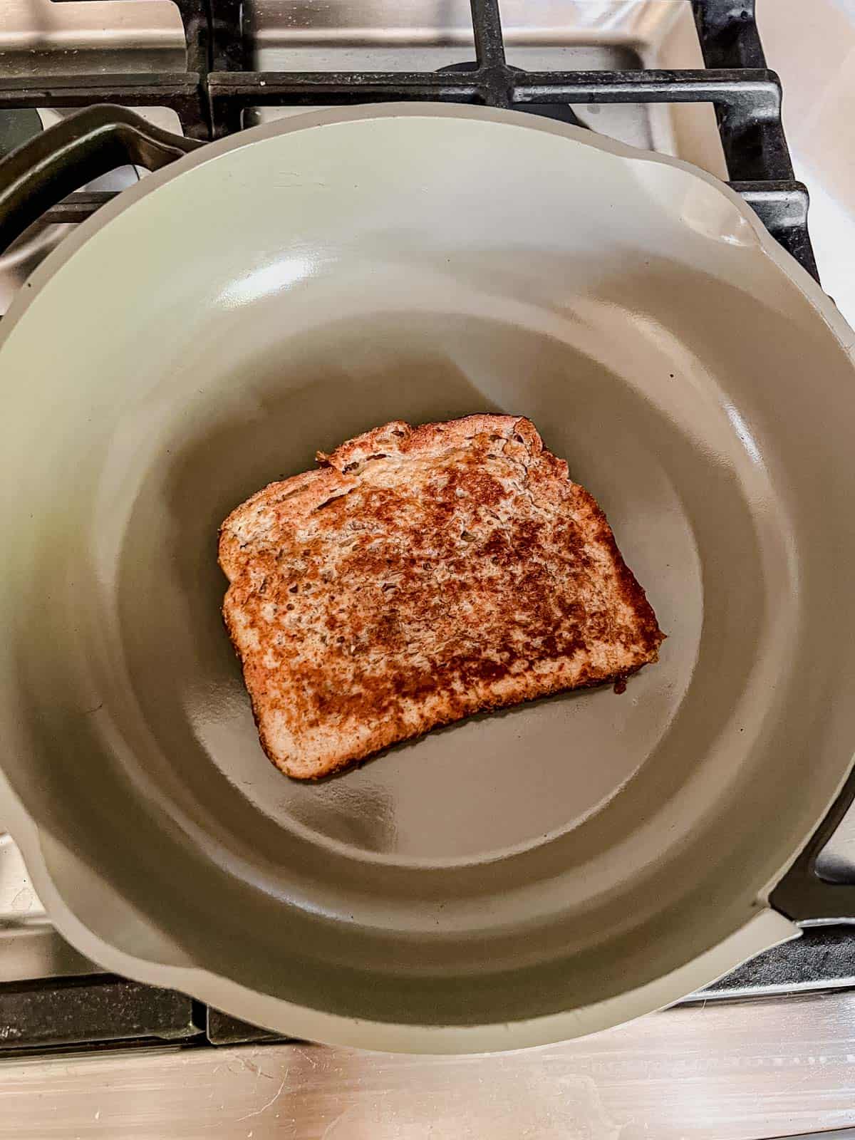 a piece of protein french toast cooking in a skillet.