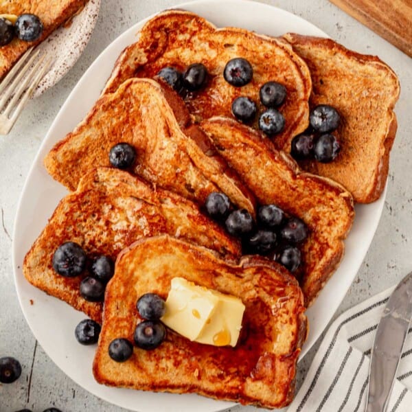 a platter of protein french toast with blueberries and syrup.