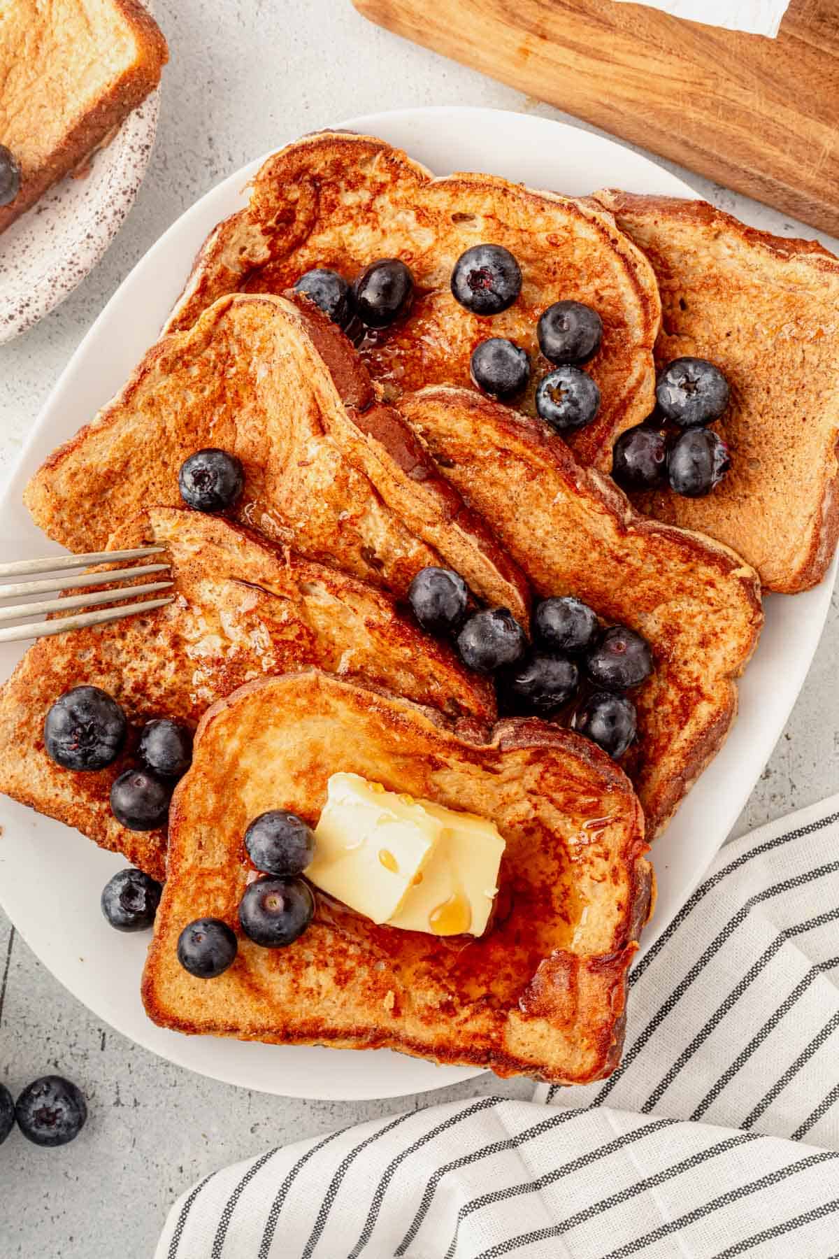 6 pieces of protein french toast on a platter with butter and syrup.