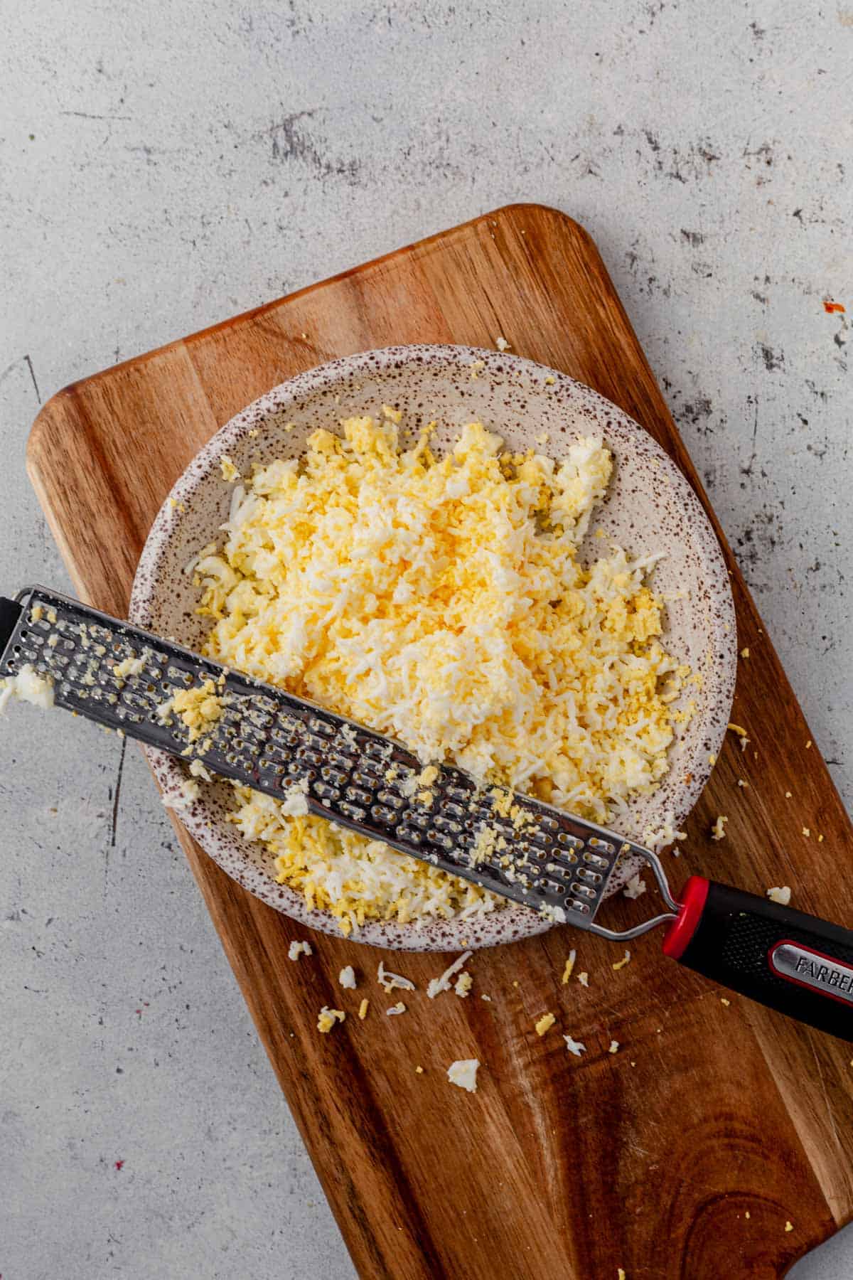 grated hard boiled egg in a dish with a microplane grater.