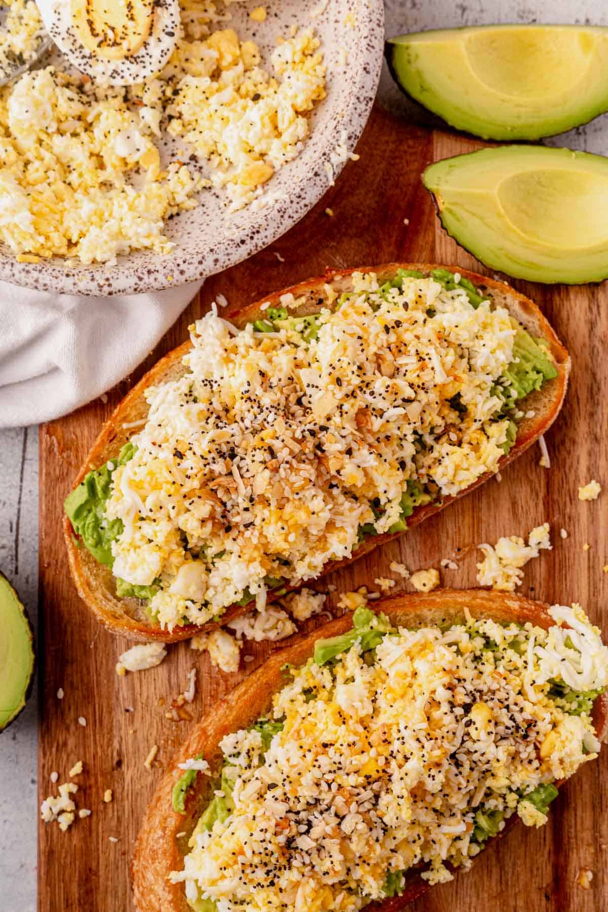 grated egg avocado toast topped with everything bagel seasoning and hot honey.