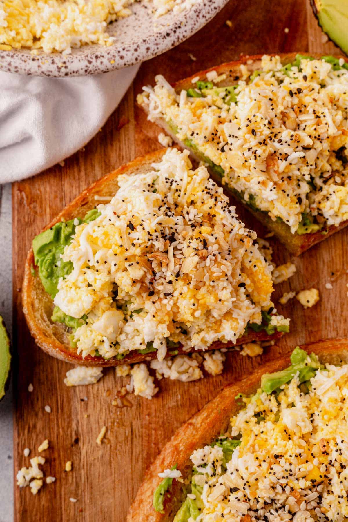 a piece of grated egg avocado toast cut in half.