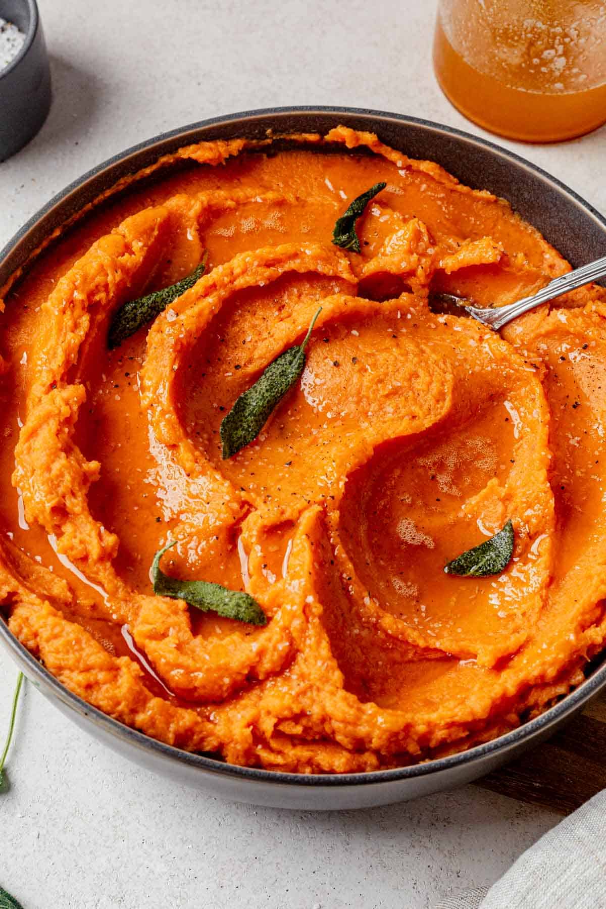 brown butter mashed sweet potatoes in a serving bowl with fried sage.