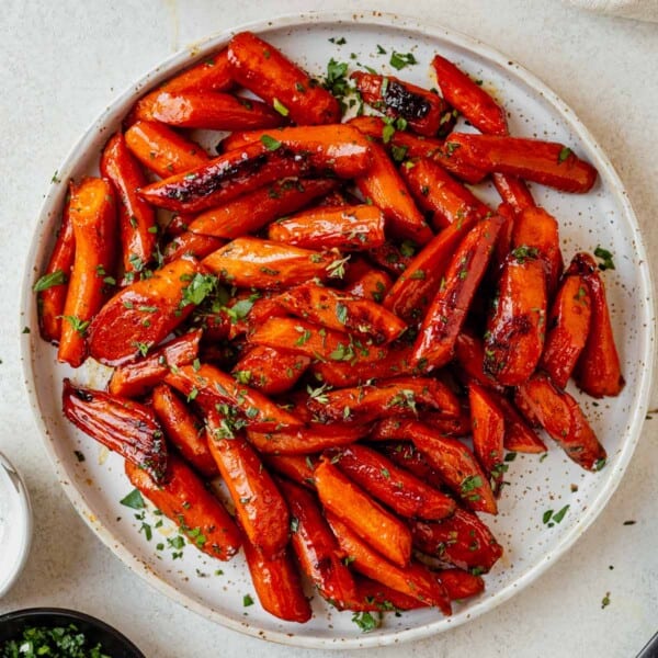 a plate of brown sugar baked carrots with parsley.