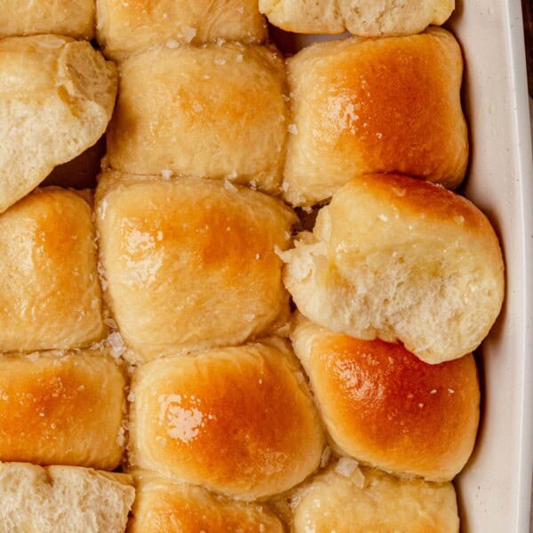 a pan of freshly baked cottage cheese dinner rolls topped with butter.