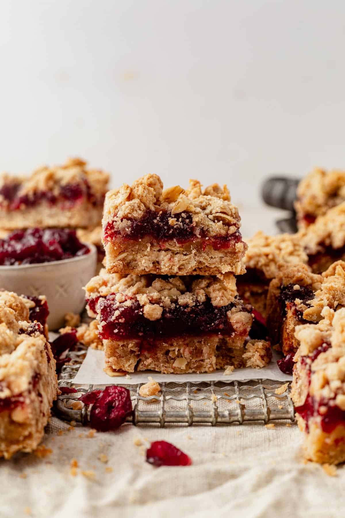 two cranberry oatmeal bars stacked on a cooling rack.