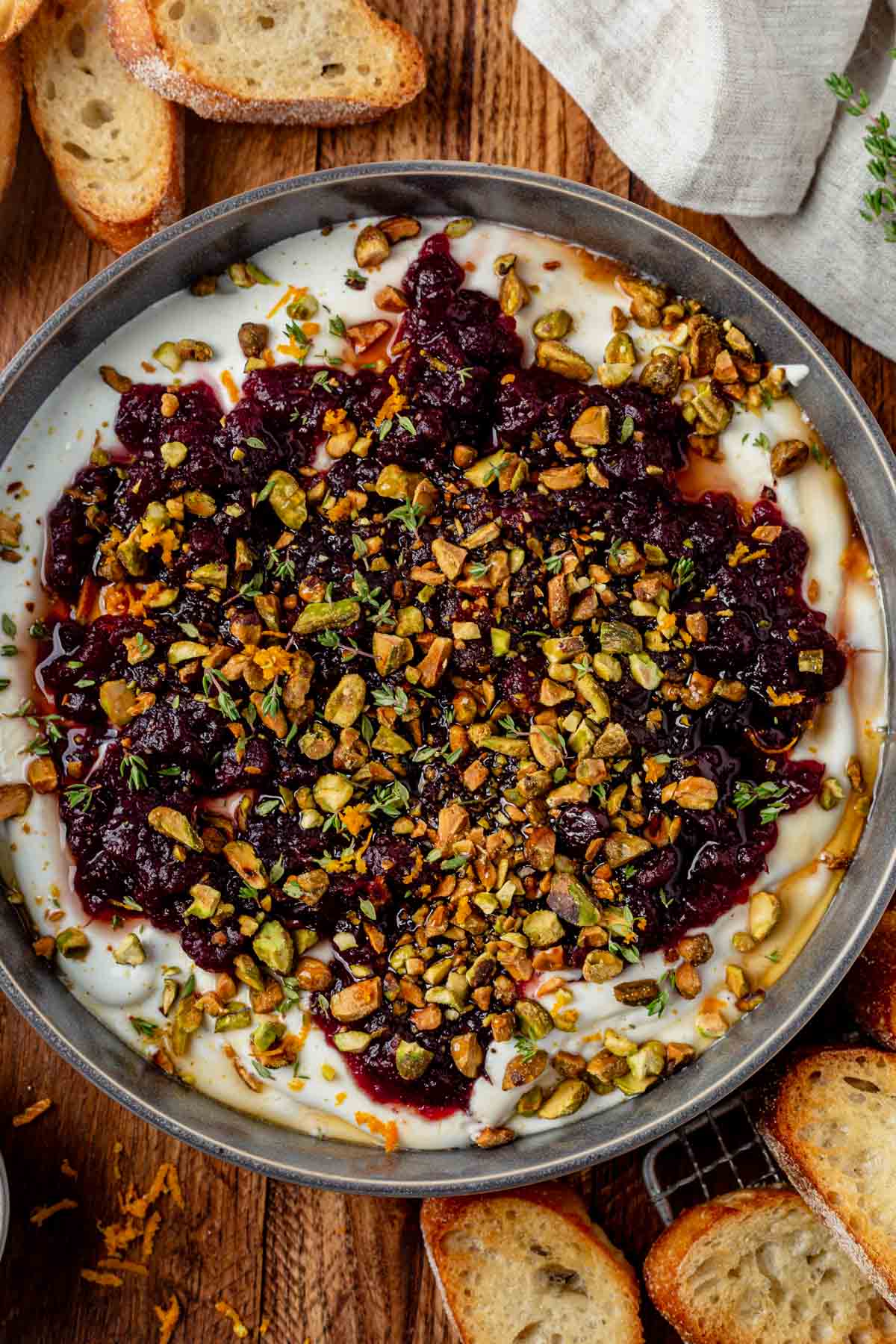 cranberry whipped feta in a serving bowl with crusty bread on the side.