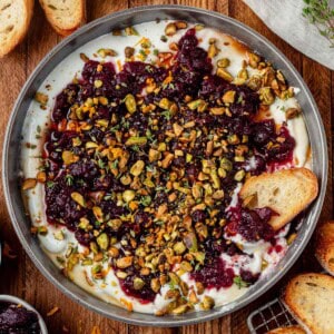 cranberry whipped feta dip in a serving bowl with crostini.