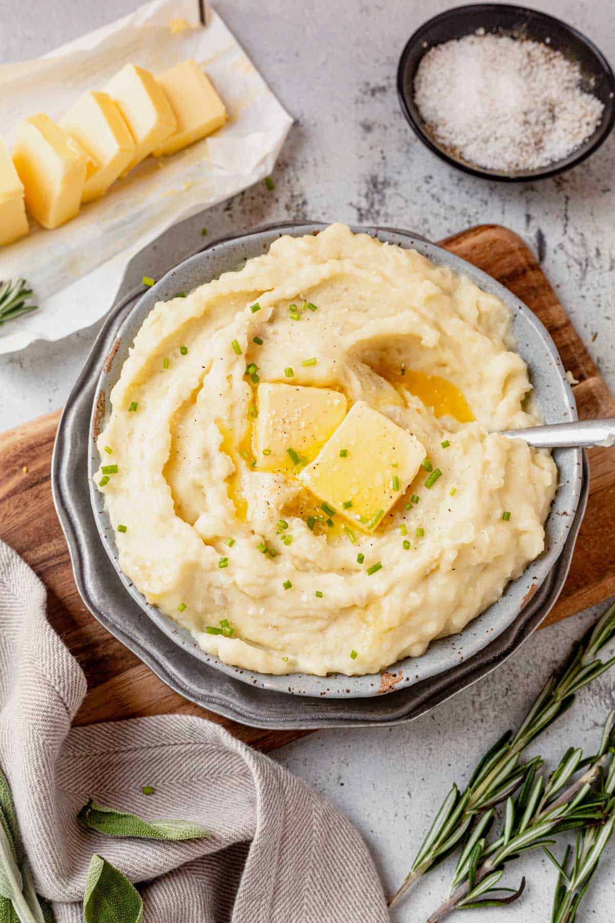 a bowl of crock pot mashed potatoes topped with butter.