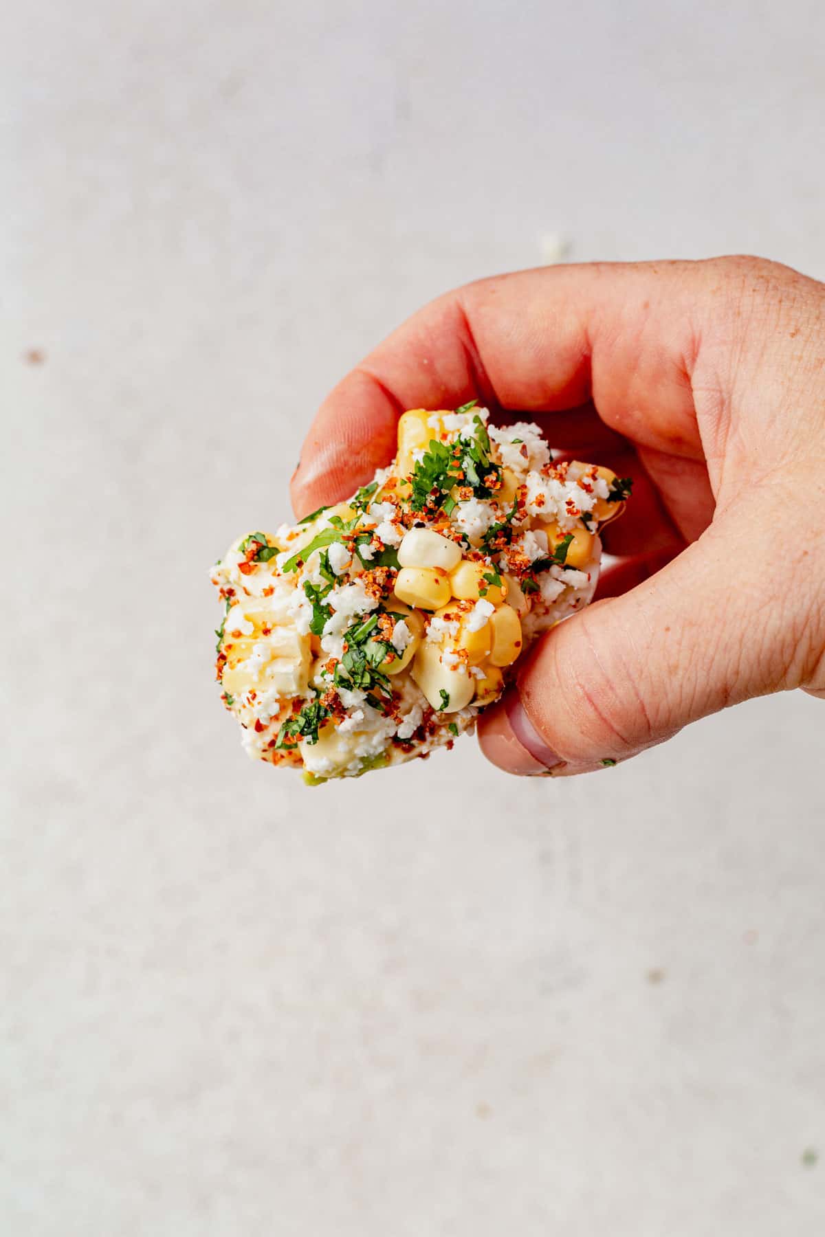 holding a mexican street corn hard boiled egg.