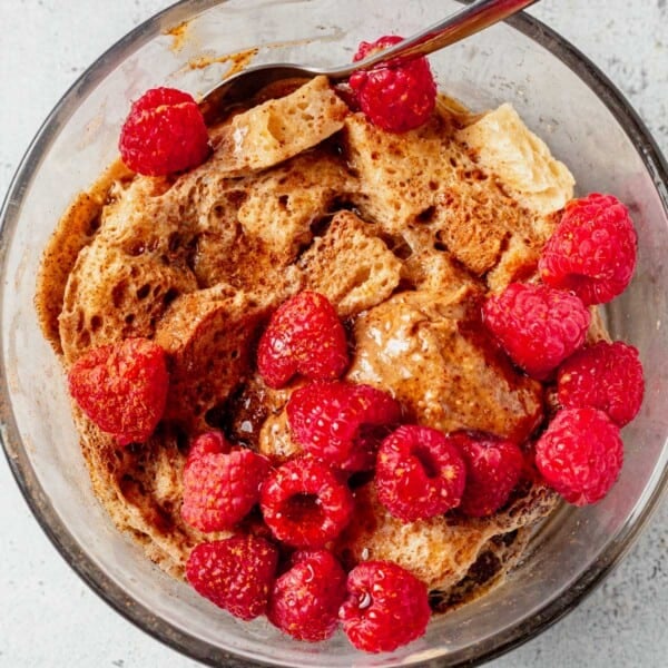 microwave protein french toast in a bowl with berries and peanut butter.