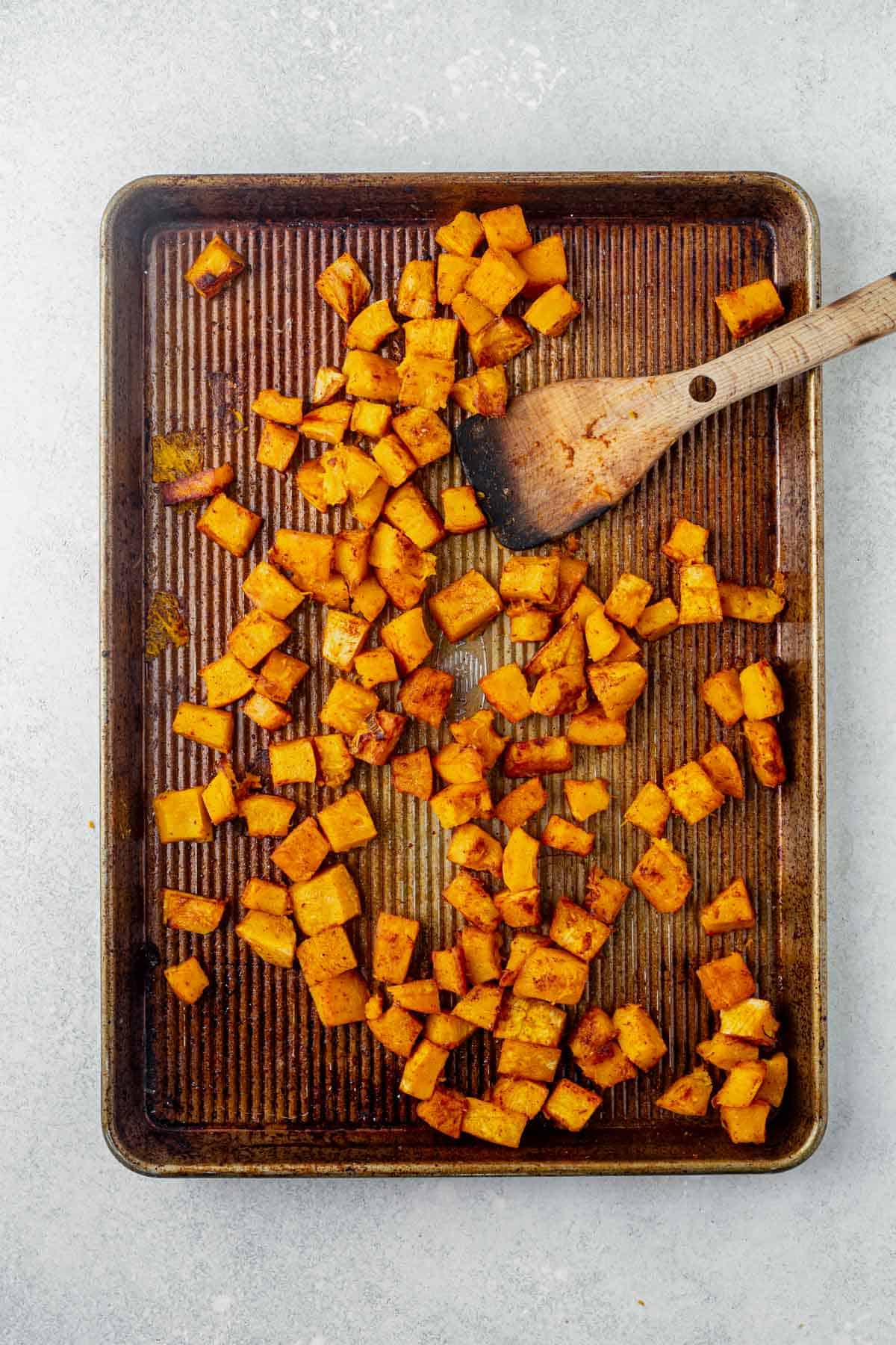 diced roasted pumpkin on a baking sheet.