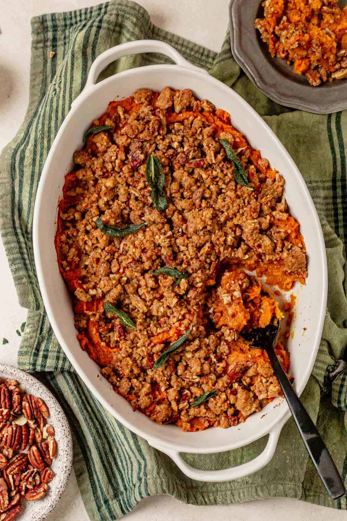 sweet potato streusel casserole in a dish with a serving spoon.