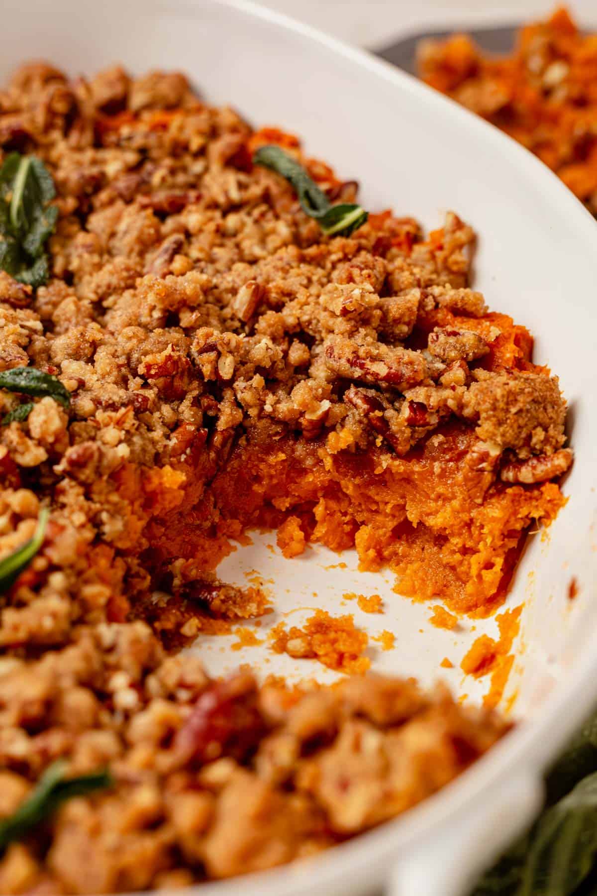 sweet potato streusel casserole with a spoonful missing from the dish.