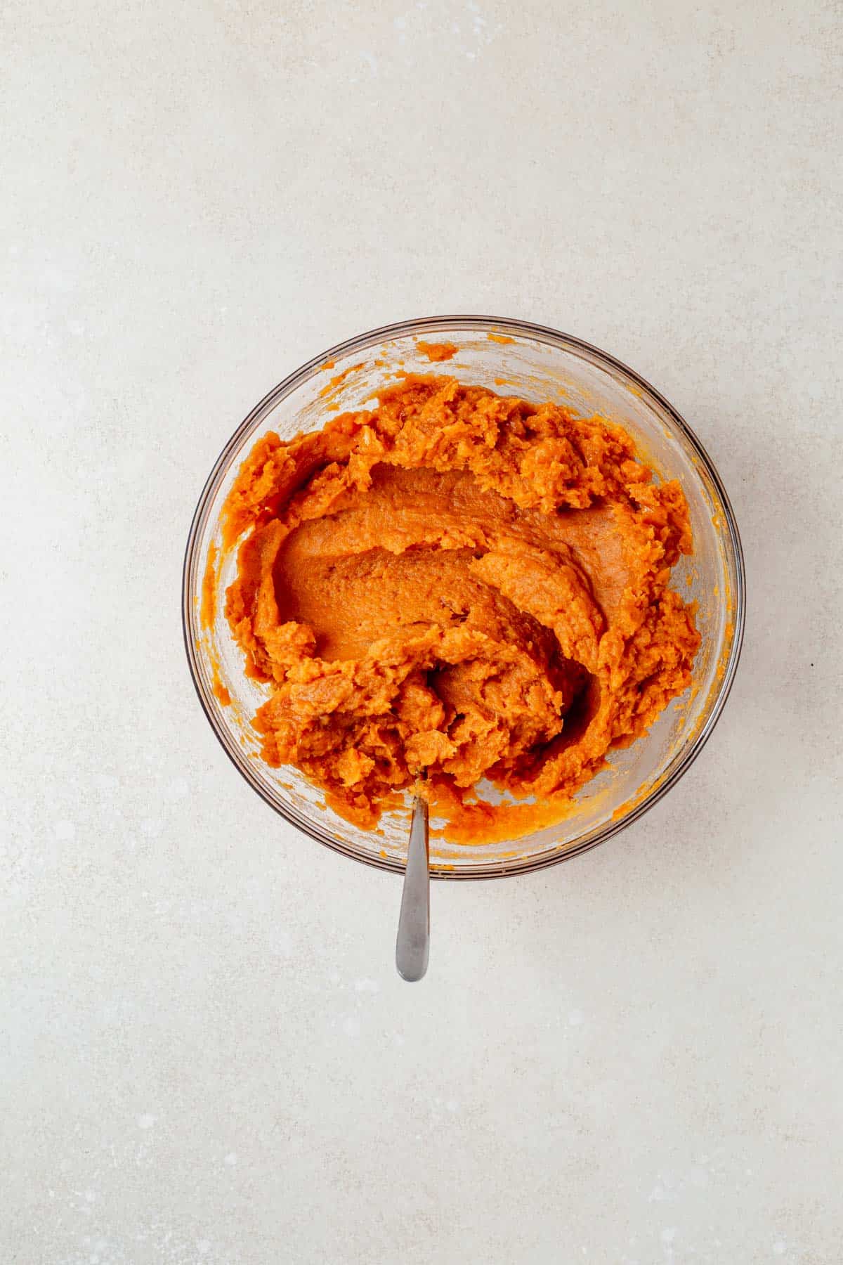 sweet potato casserole filling in a mixing bowl on a counter top.